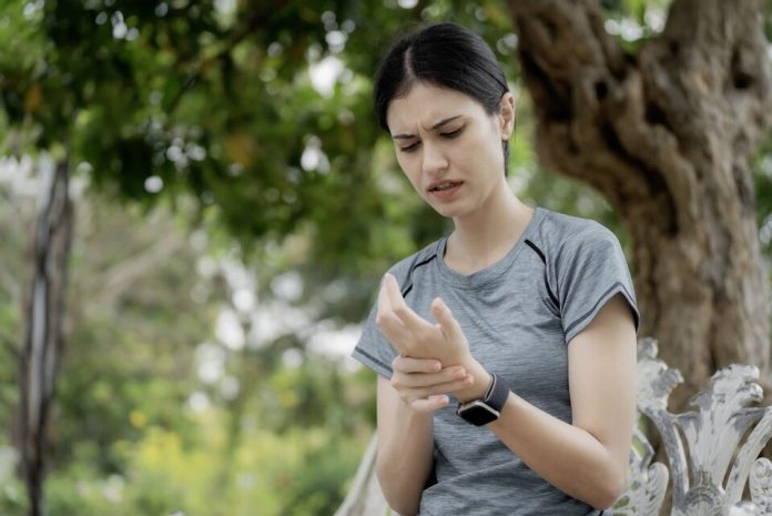 Young,Woman,Feeling,Numbness,And,Tingling,In,Fingers,After,Outdoor